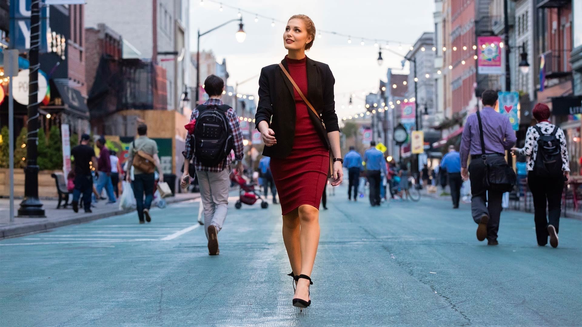 woman in red dress walking down newark avenue in jersey city