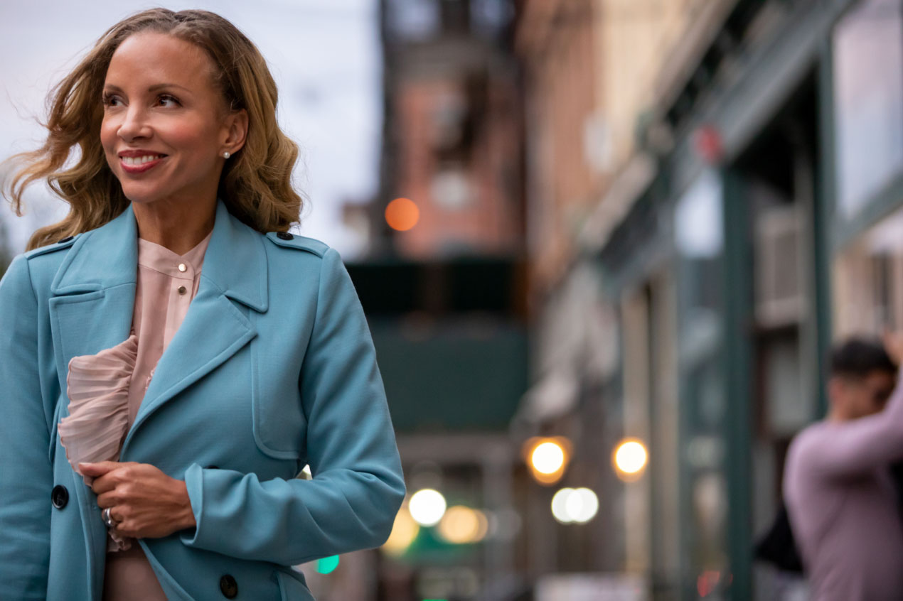 woman in blue coat walking down newark avenue in jersey city