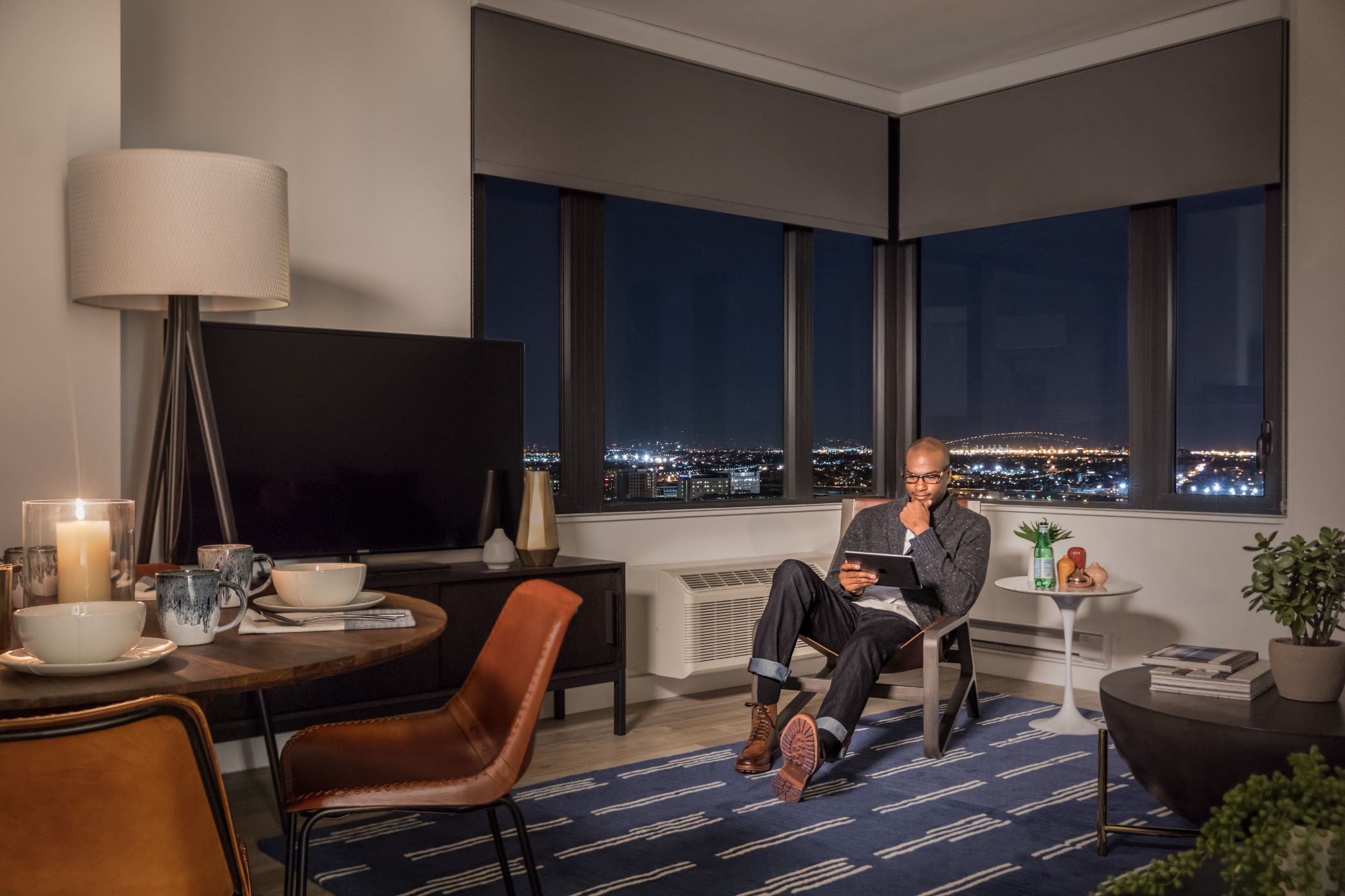 man sitting in chair in vyv corner apartment with giant corner windows