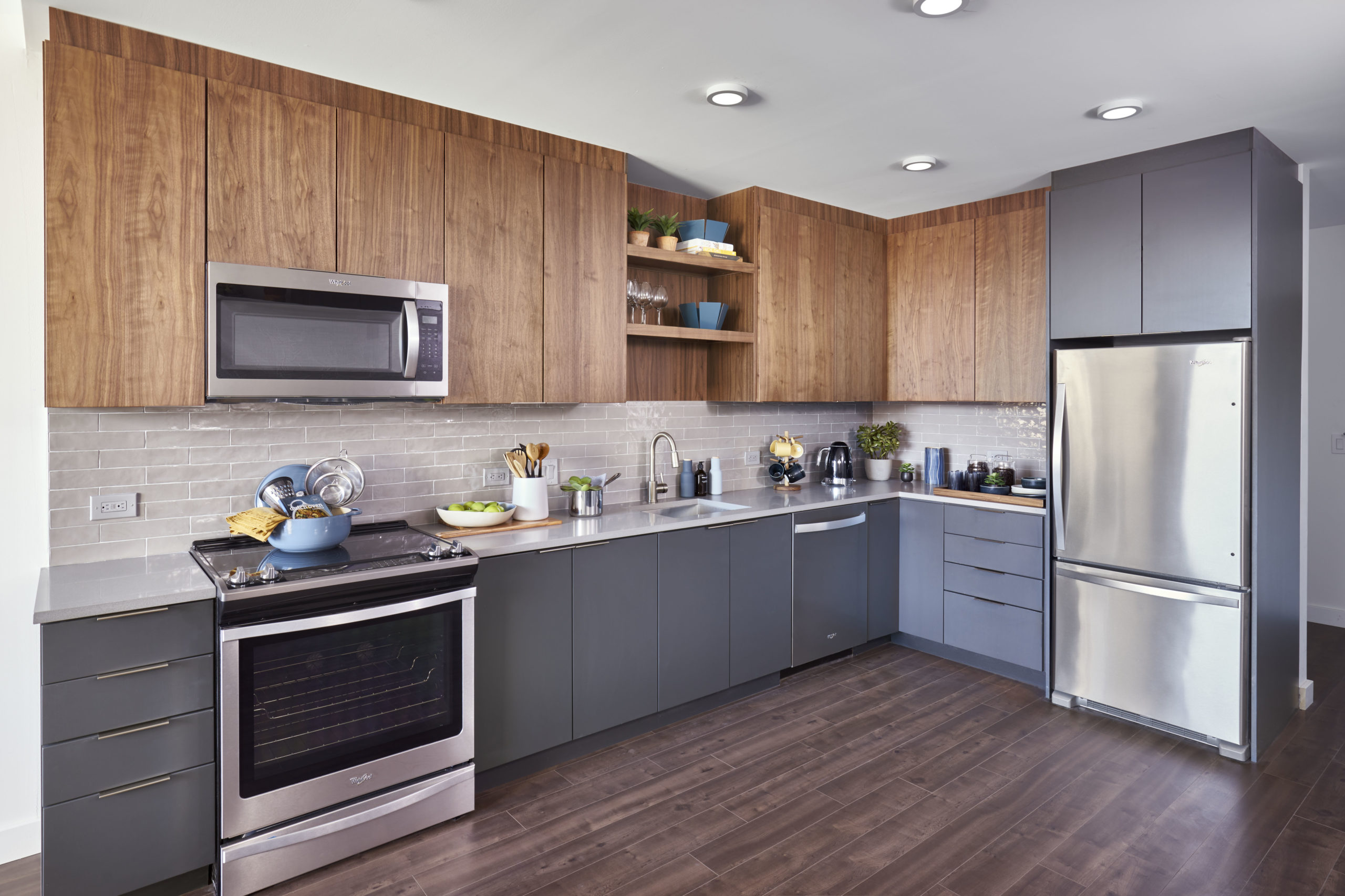 open kitchen with gray and wood cabinets and stainless steel appliances