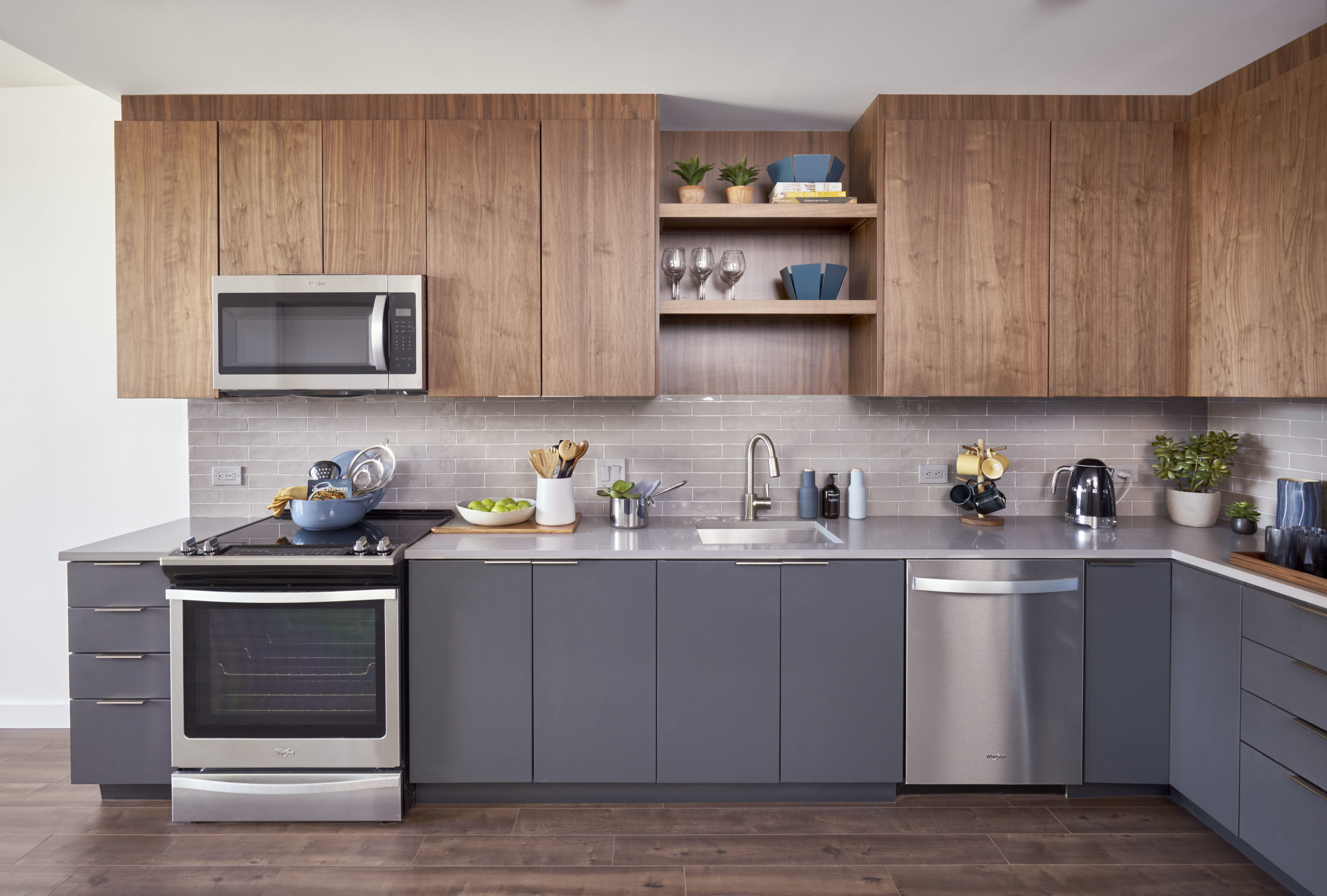 high end wood cabinets and gray counters in apartment