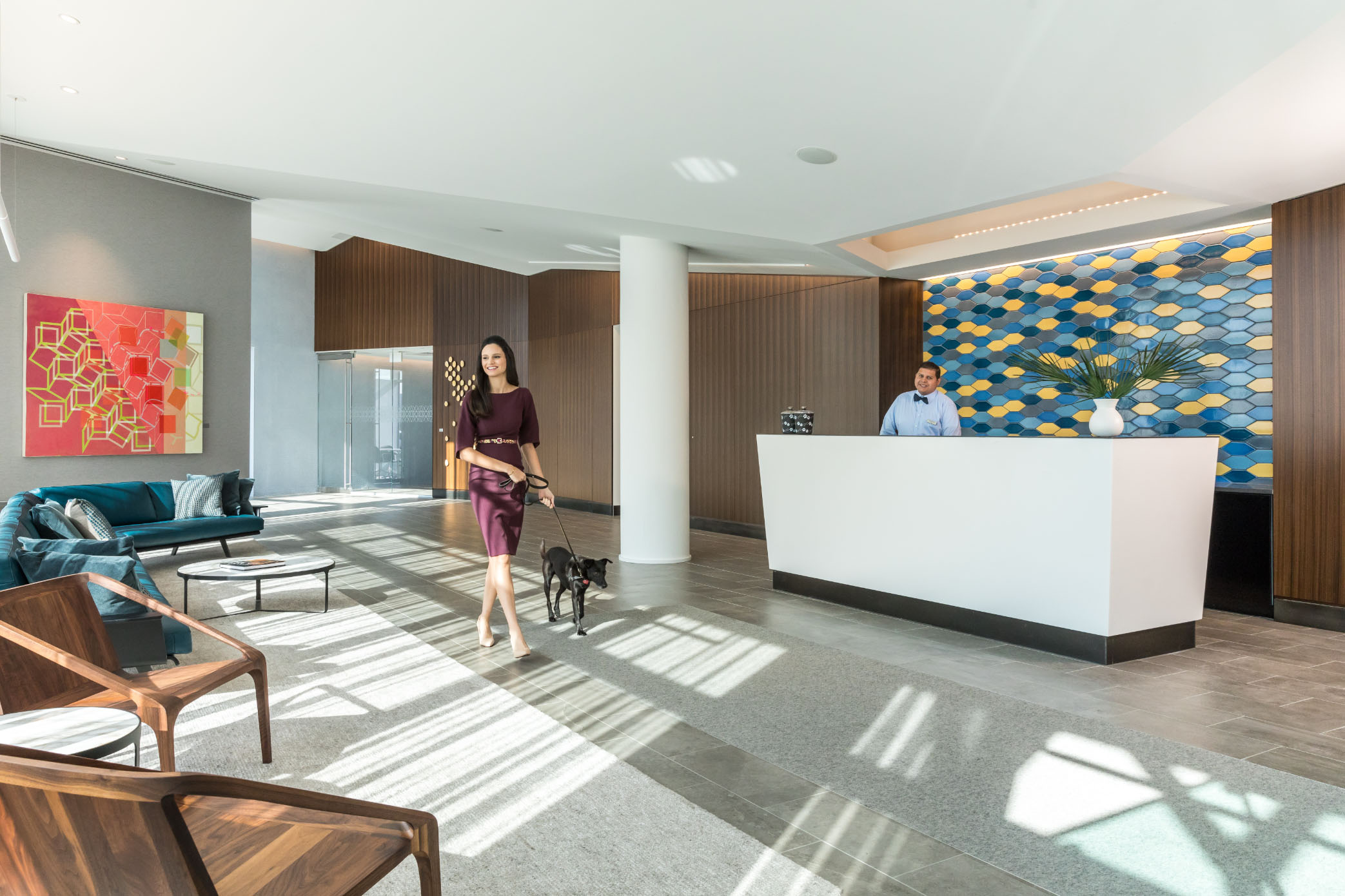 woman walking dog out of apartment lobby