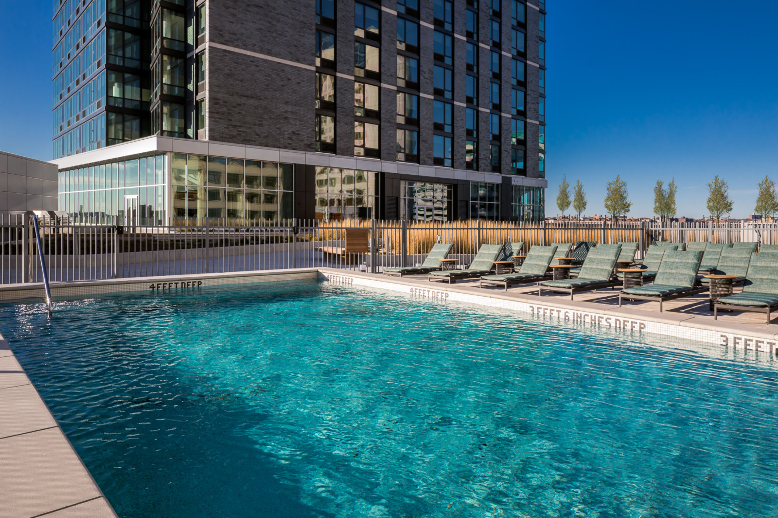 outdoor-pool-lounge-chairs pool amenities on roof deck of jersey city rental
