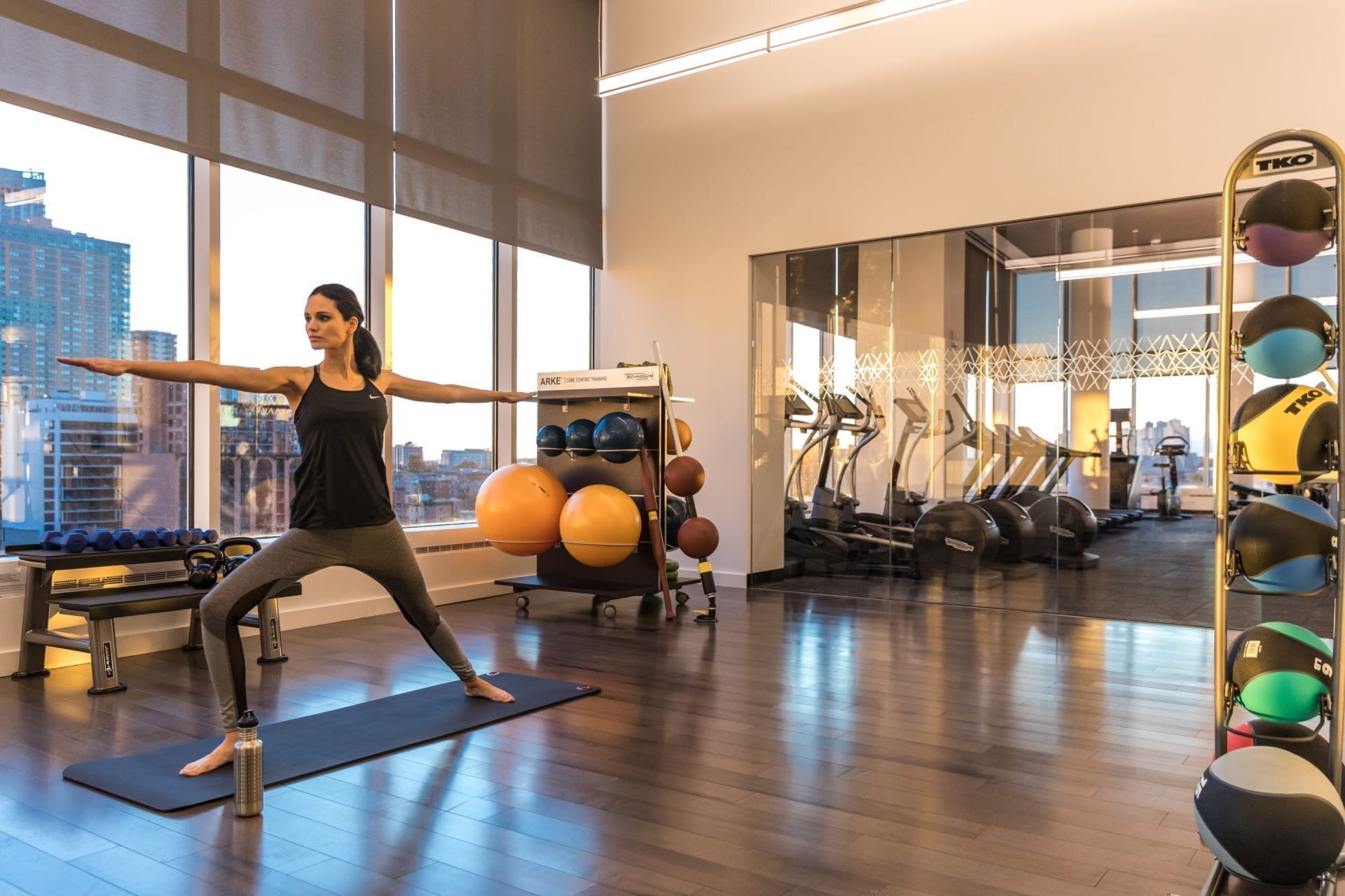 woman doing yoga in fitness center amenities in jersey city